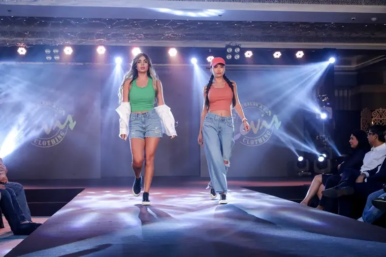 Models on a lit fashion runway