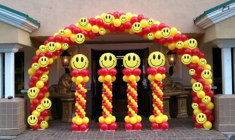 Smiley-face balloon arch at an entrance