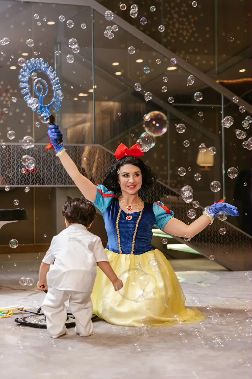 Snow White entertainer giving a bubble show to a child
